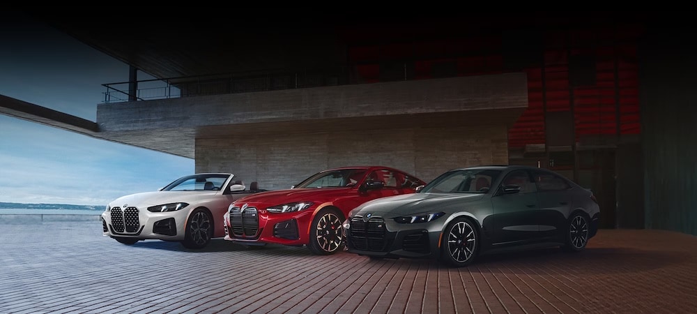 Three BMW 4-series vehicles, one white, one red, and one grey