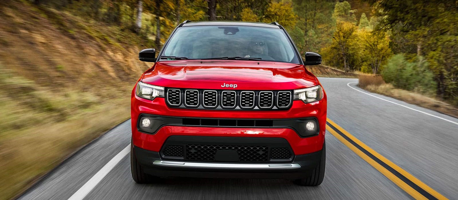 Red 2026 Jeep Compass driving on the highway