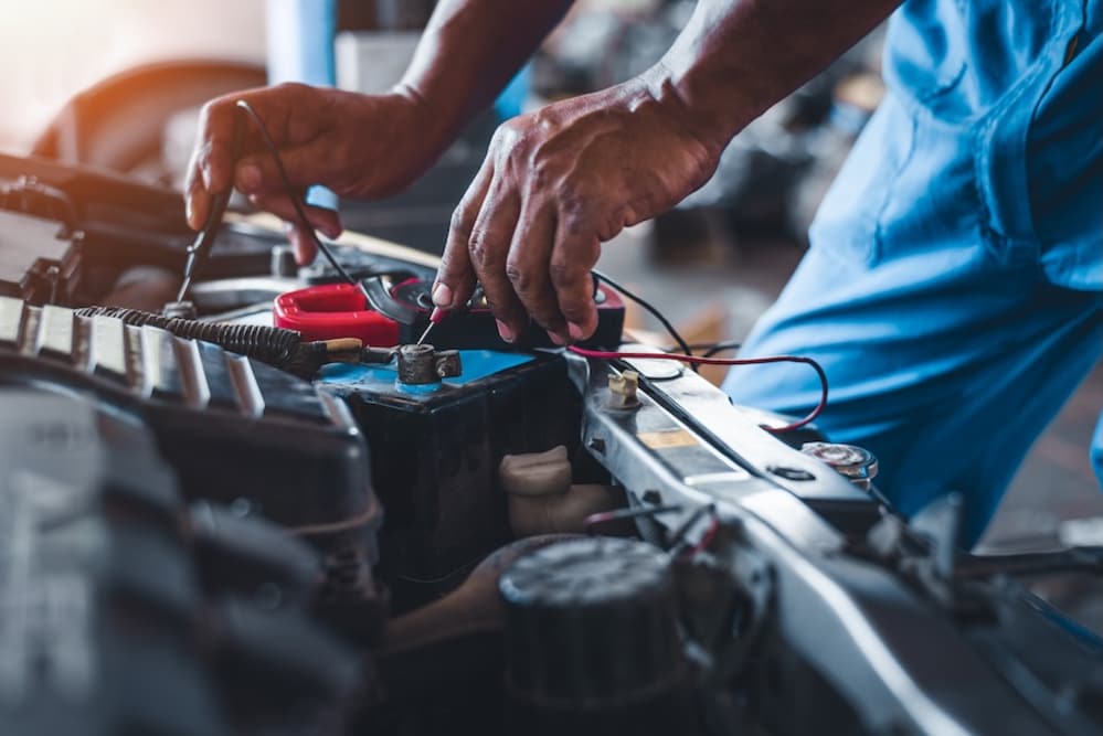 A mechanic using diagnostic tools on an engine