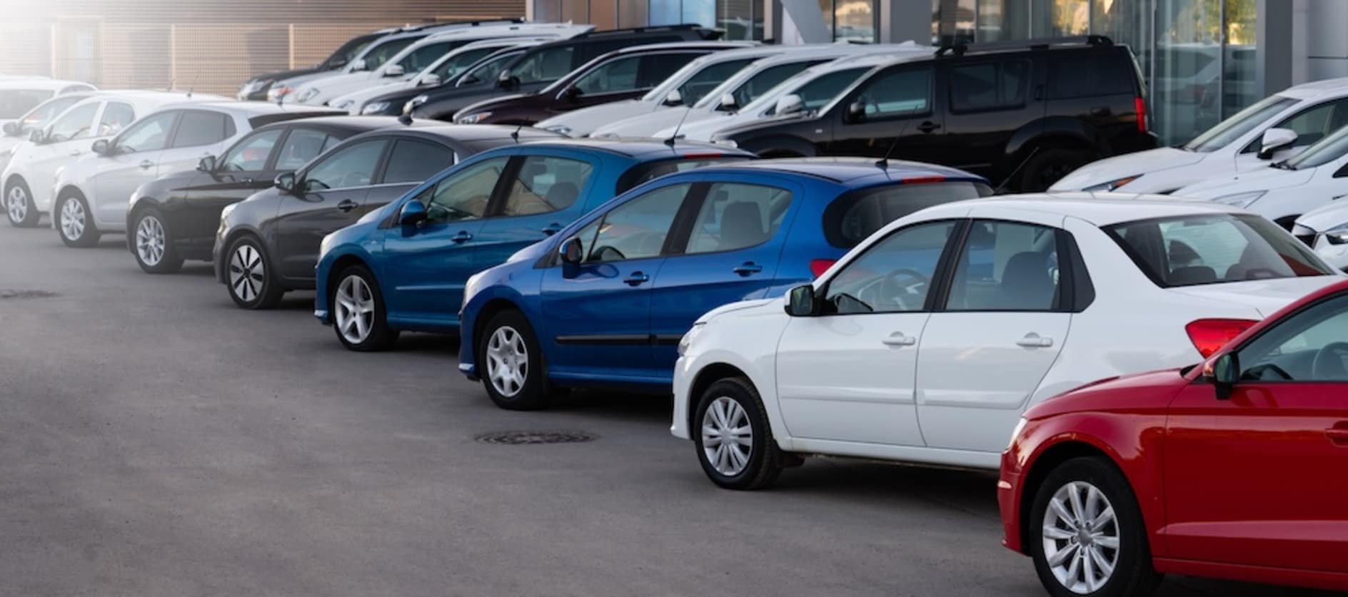 A variety of used cars parked in a used car dealership lot
