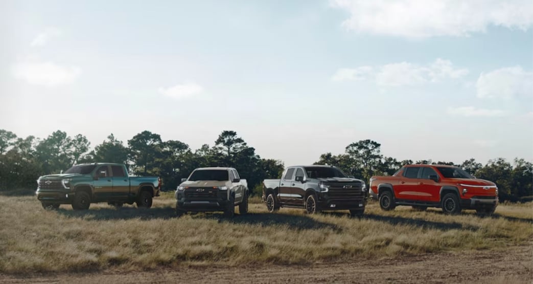 Four new Chevrolet trucks parked in a field