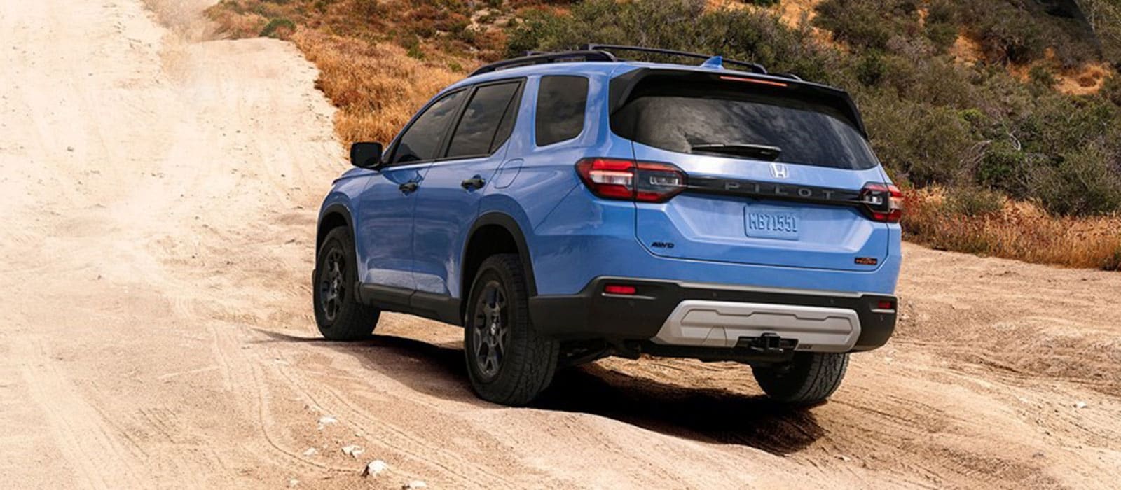 2025 Honda Pilot driving up a sandy hill