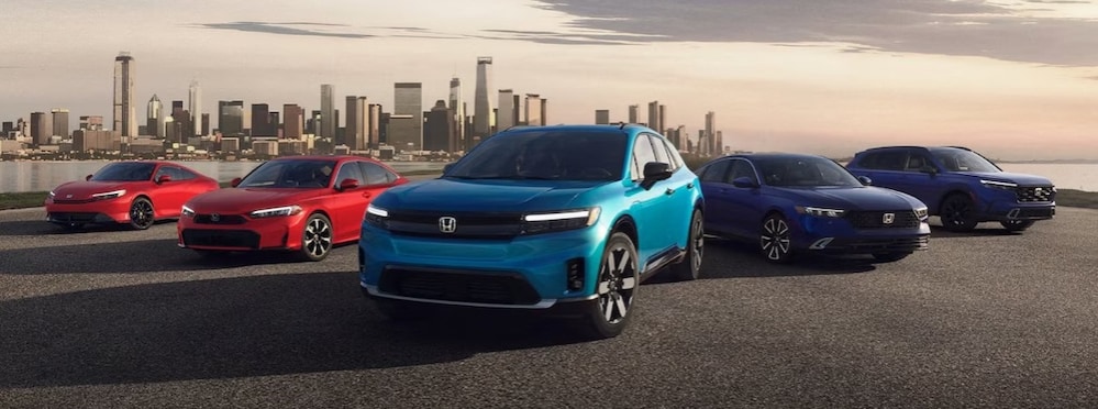 5 Honda electric vehicles parked in front of a body of water with a city skyline in the background