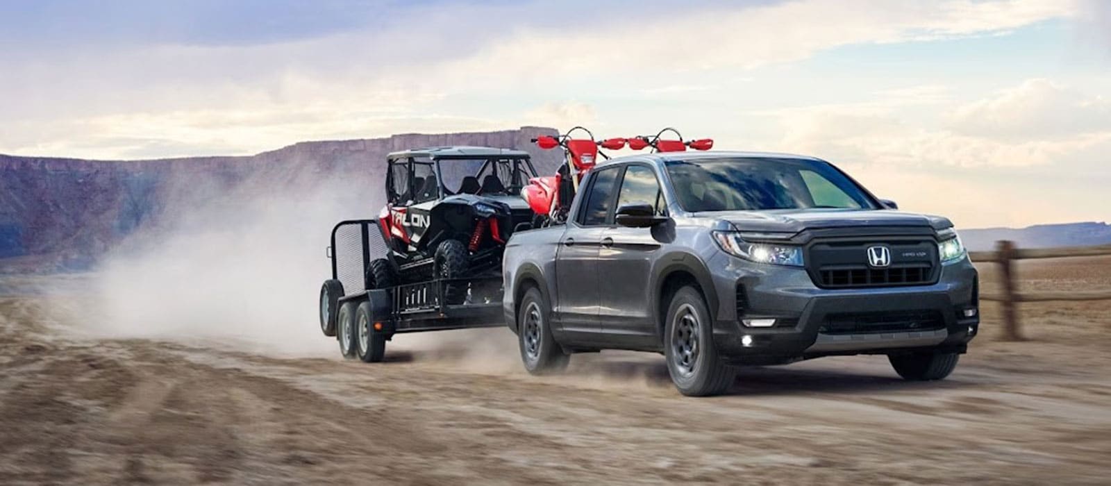 2025 Honda Ridgeline pulling a trailer on a dirt road