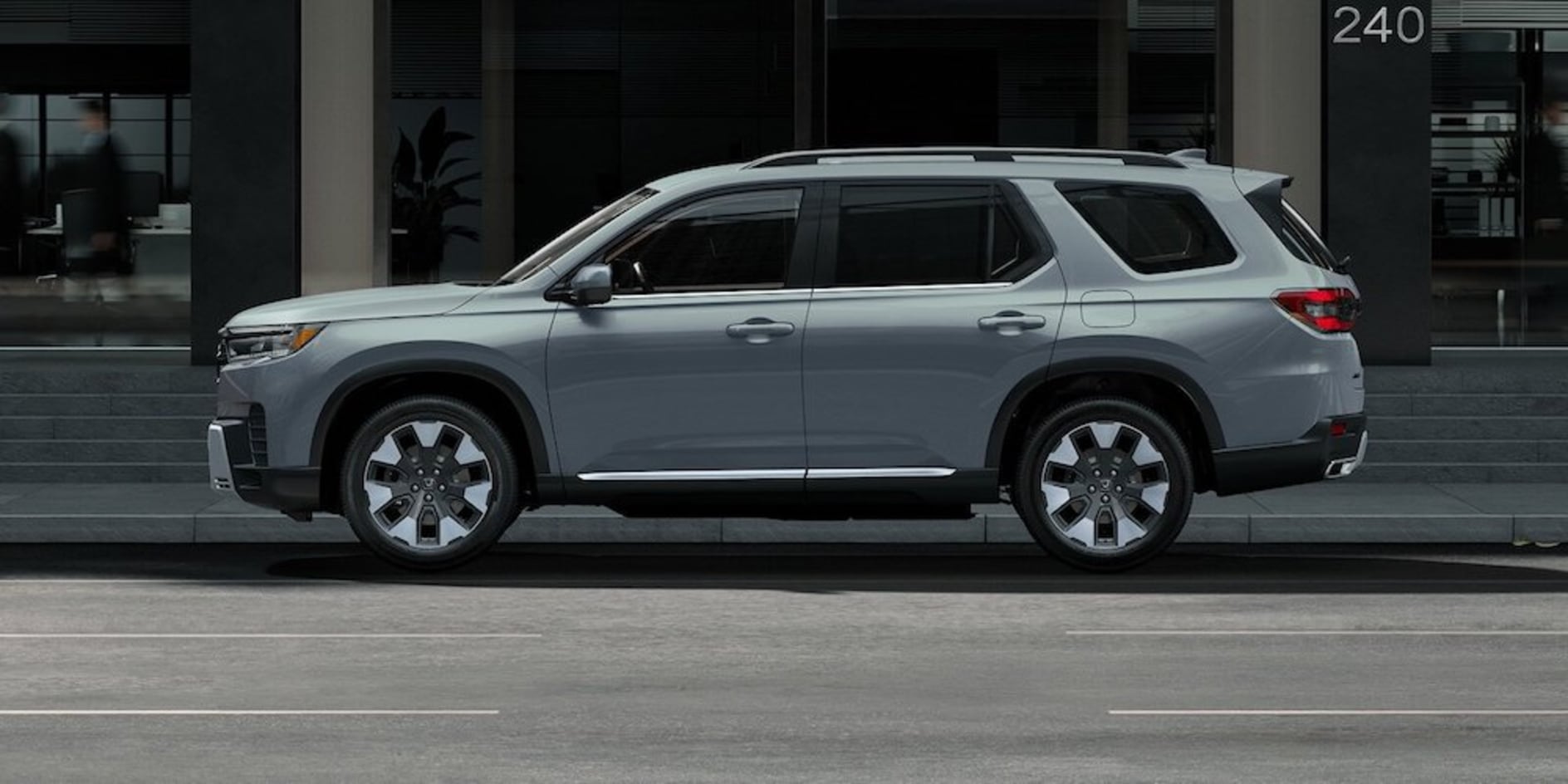 A gray 2026 Honda Pilot SUV driving down a city street