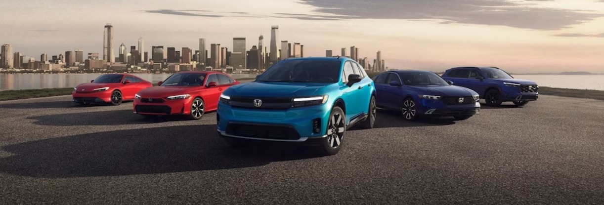 Five Honda vehicles parked in front of a river, with a city skyline in the distance