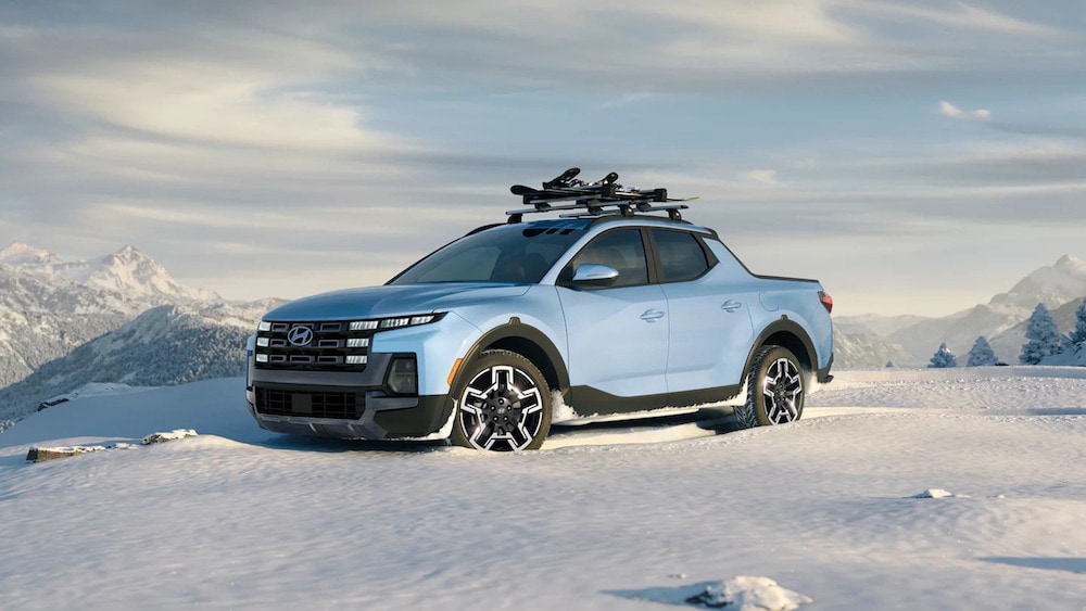 A light blue 2026 Hyundai Santa Cruz parked on a snowy mountaintop