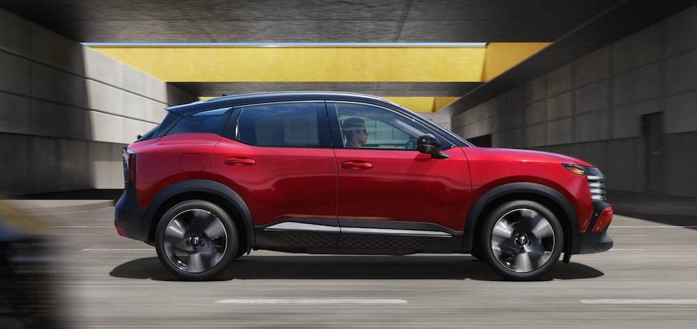 A side view of a red 2026 Nissan kicks SUV