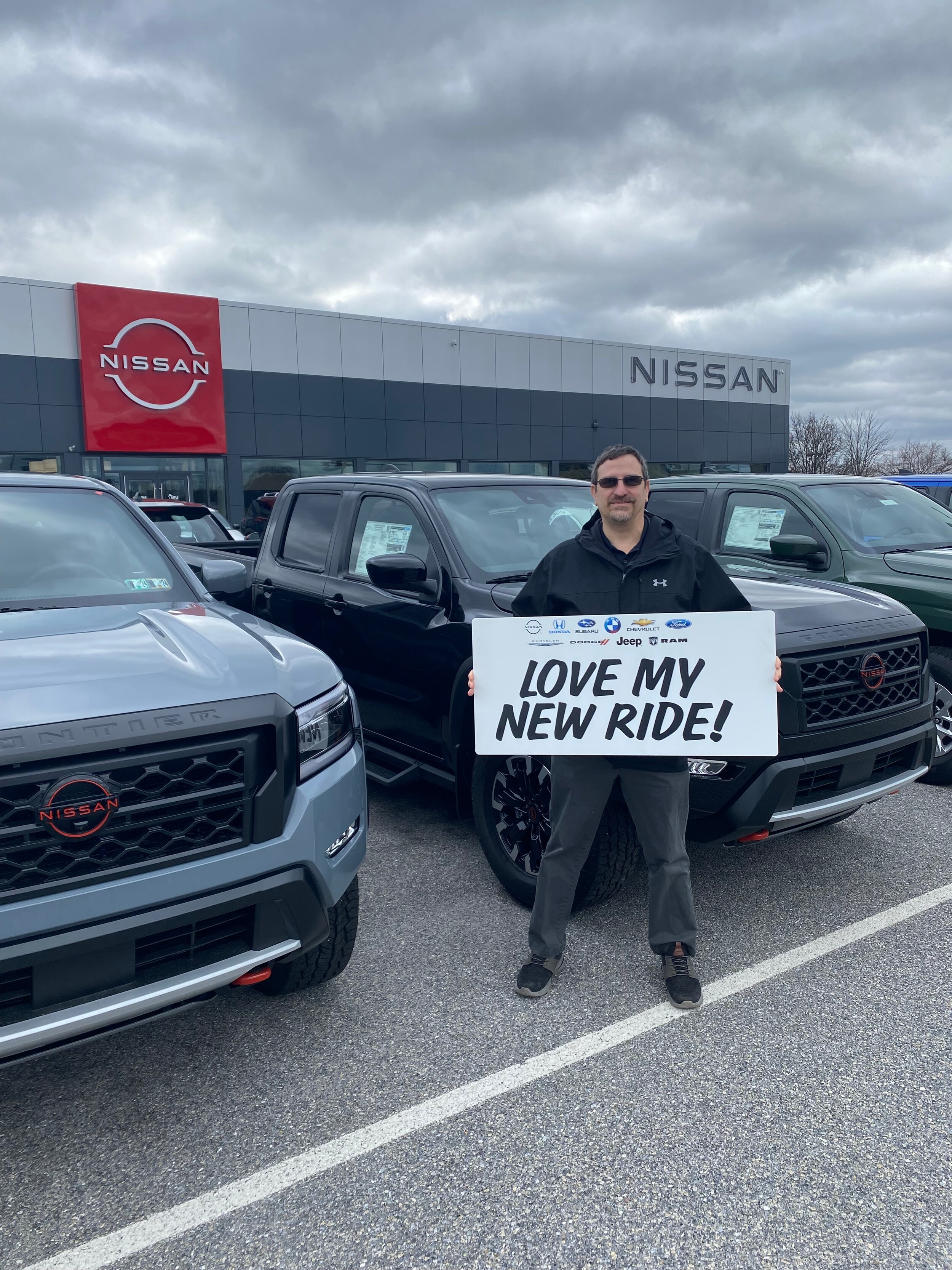 happy sales rep in Nissan parking lot