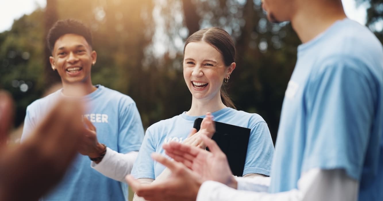 A group of volunteers smiling and applauding