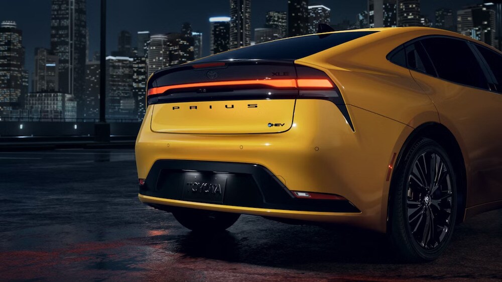 The back of a yellow 2026 Toyota Prius with black wheels and rims