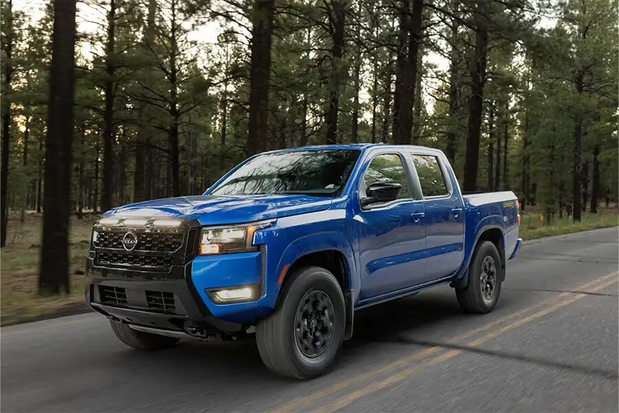 2027 Nissan Frontier driving off-road in rugged mountain terrain