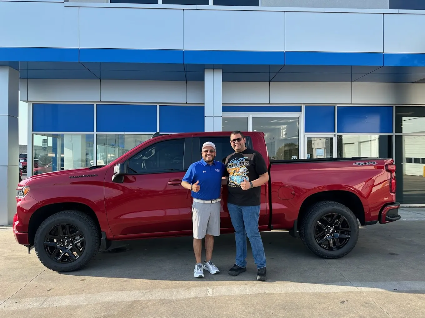 Happy couple posing next to a recently purchased Chevy truck from Classic Chevrolet