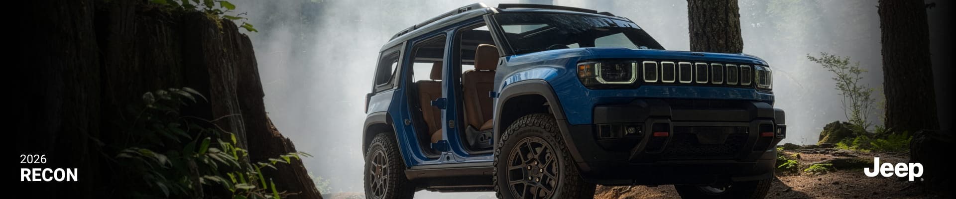 Jeep Recon with its doors open parked in a misty forest and conveying a sense of adventure and rugged capability.