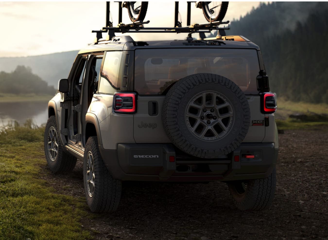 A 2026 Jeep Recon is parked by a serene river at dusk.