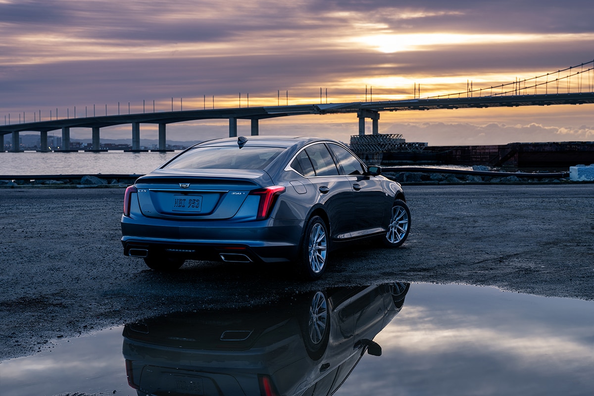 A Cadillac CT5 parked with a view of a long bridge