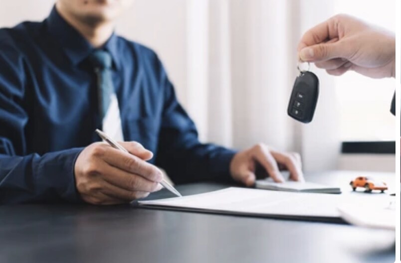 Someone signing a lease agreement for a car
