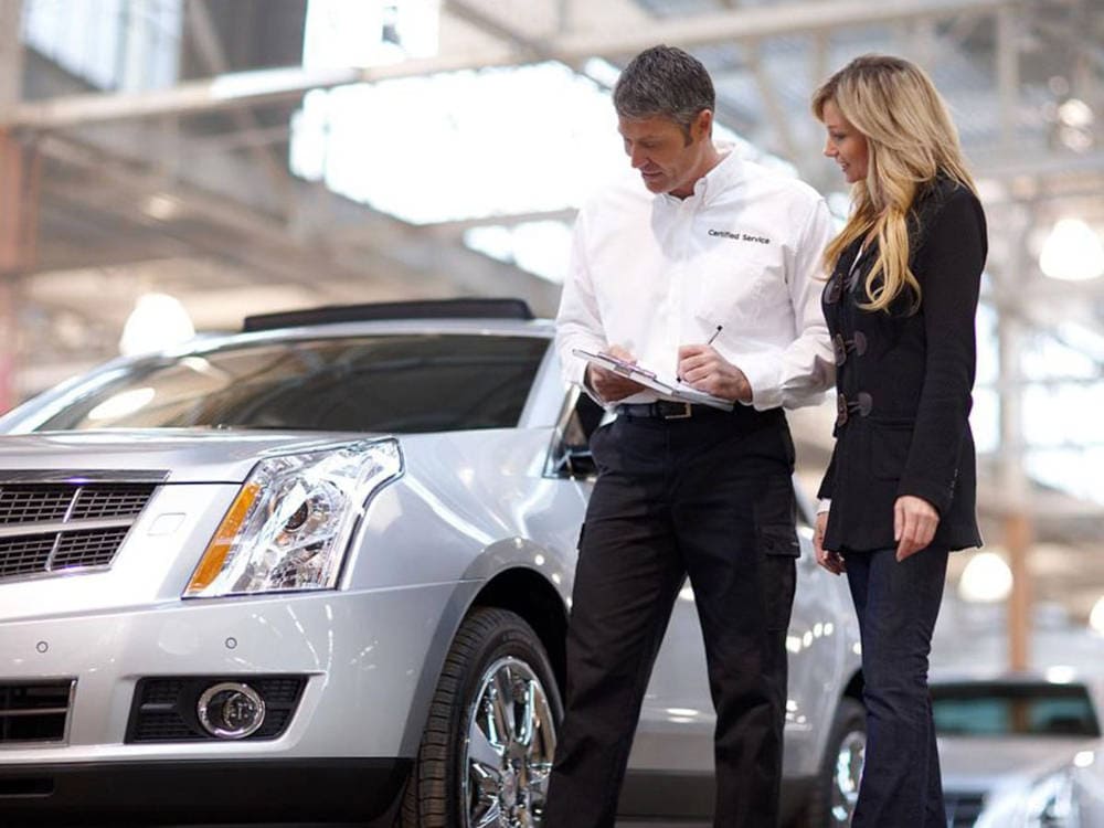 Cadillac mechanic talking to a customer