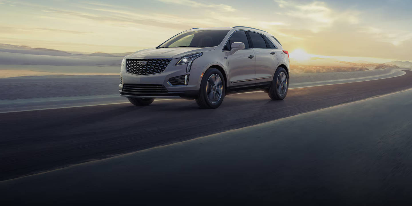 Cadiallac driving in the winter with sunset in the rear