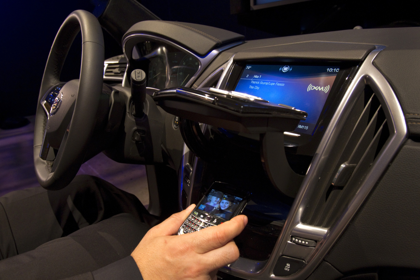 Driver using the Cadillac CUE dashboard and center console