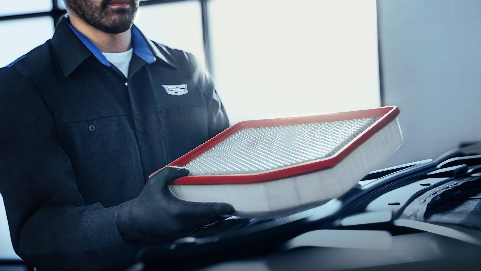 Cadillac Mechanic servicing an air filter