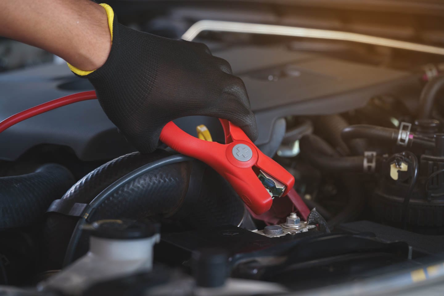 Mechanic Jump Starting Car Battery with Jumper Cables