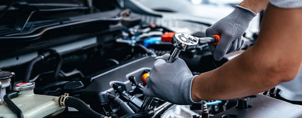 Cadillac mechanic servicing an engine