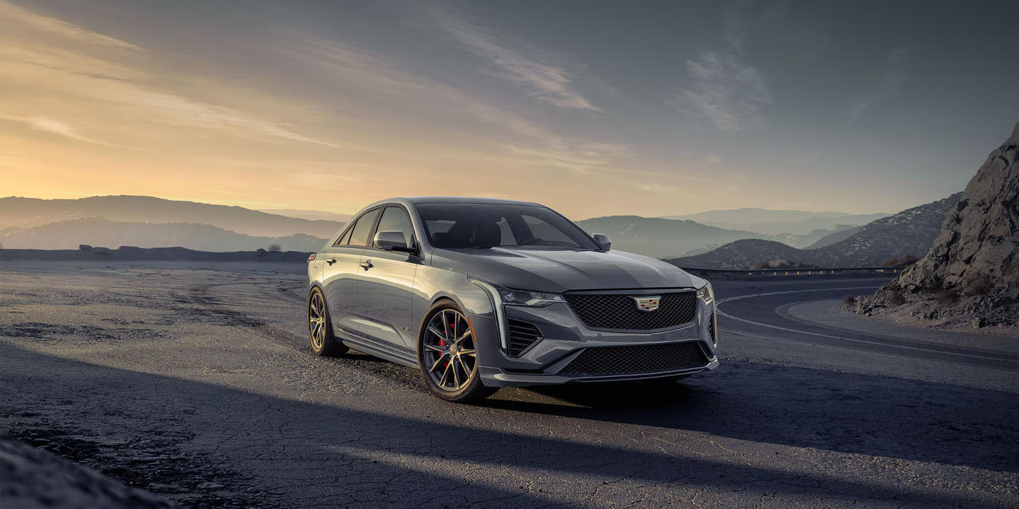 Silver 2026 Cadillac CT4-V parked on a mountain road at sunset