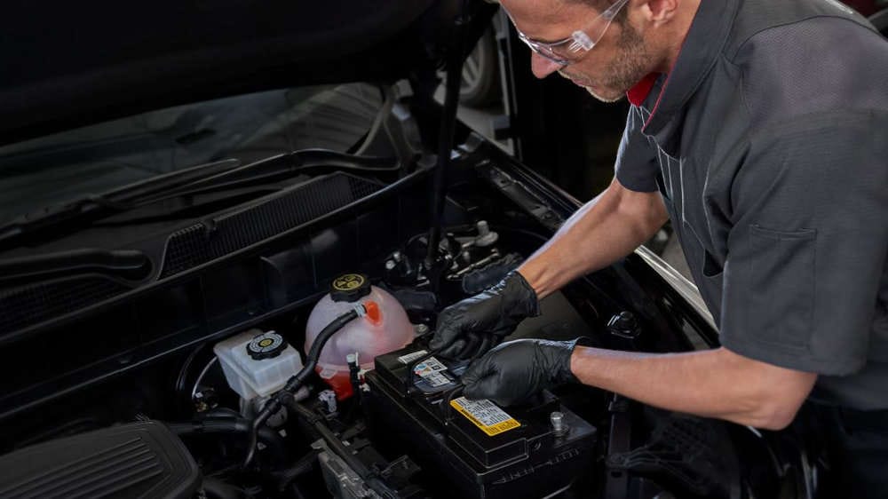 Cadillac mechanic servicing an engine