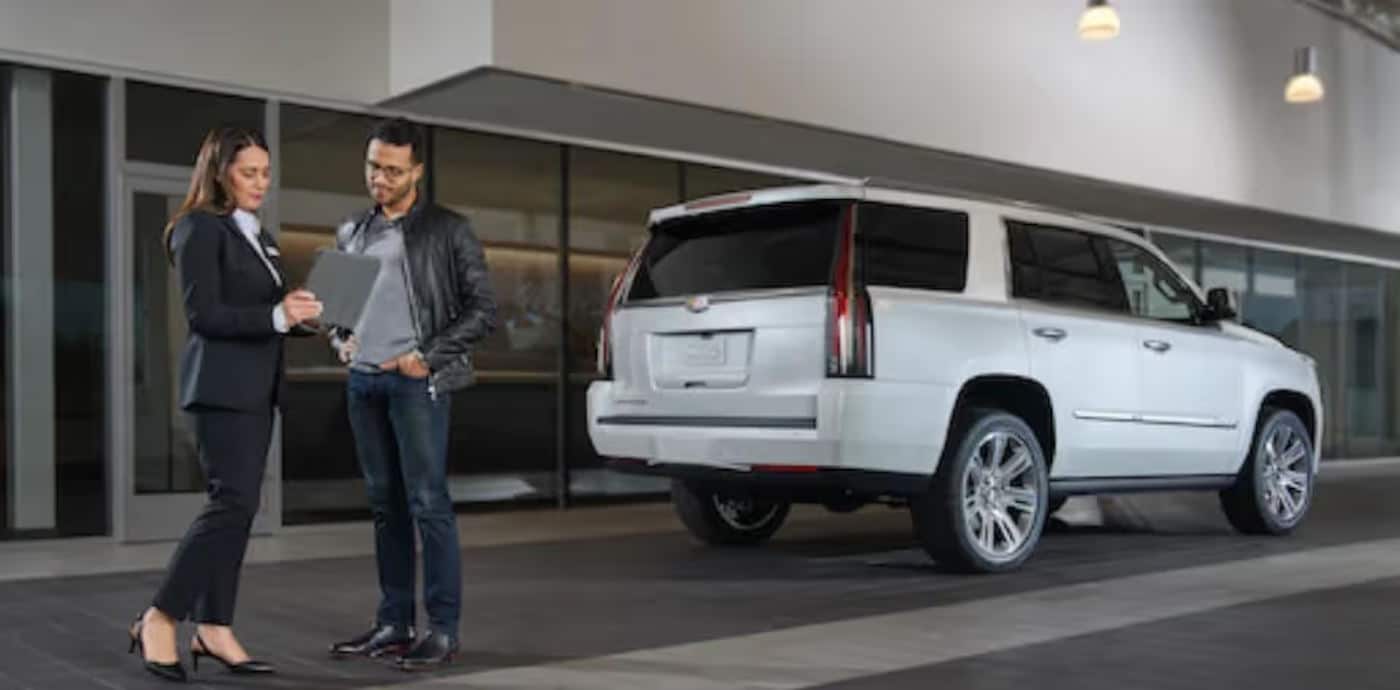 Car dealer businesswoman Reviewing lease paper with a customer.