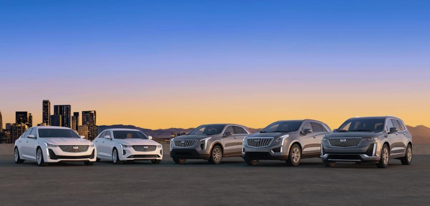all Cadillac models parked in front of a cityscape