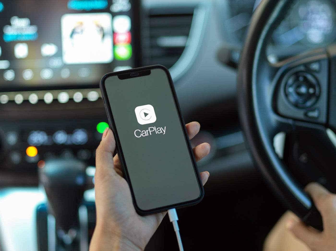 female hand holding smartphone with CarPlay application