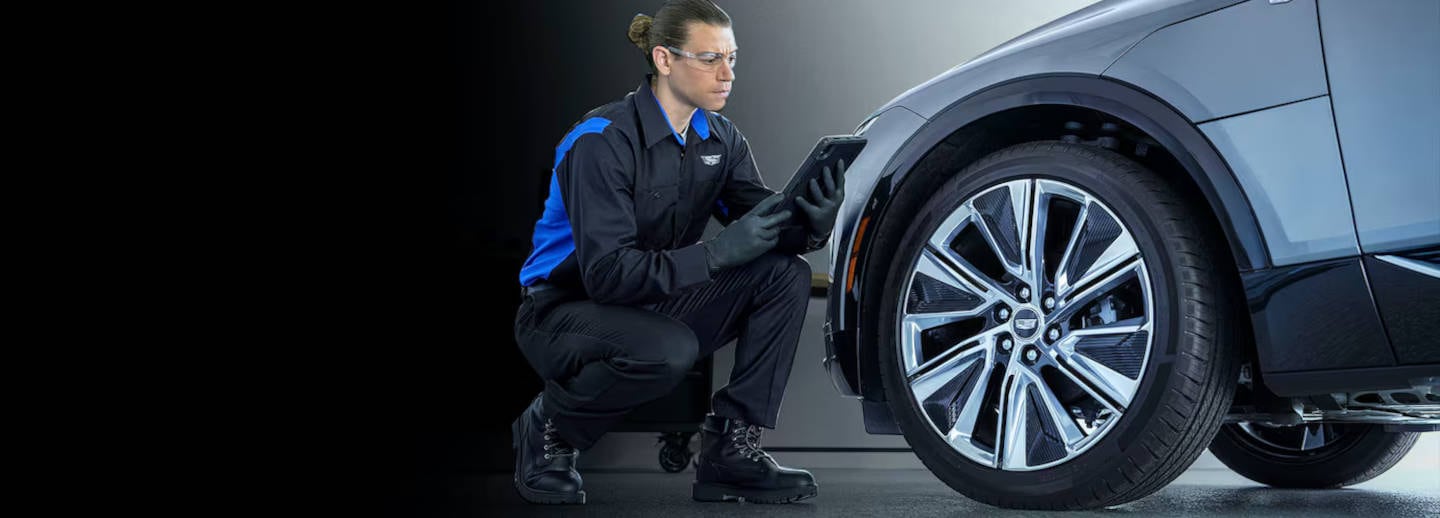 Picture of Cadillac being serviced by a technician