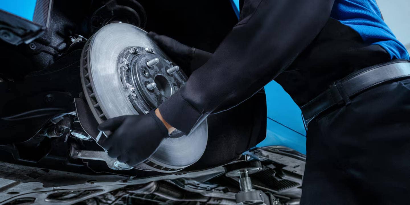 Mechanic removing a wheel to work on Cadillac brakes