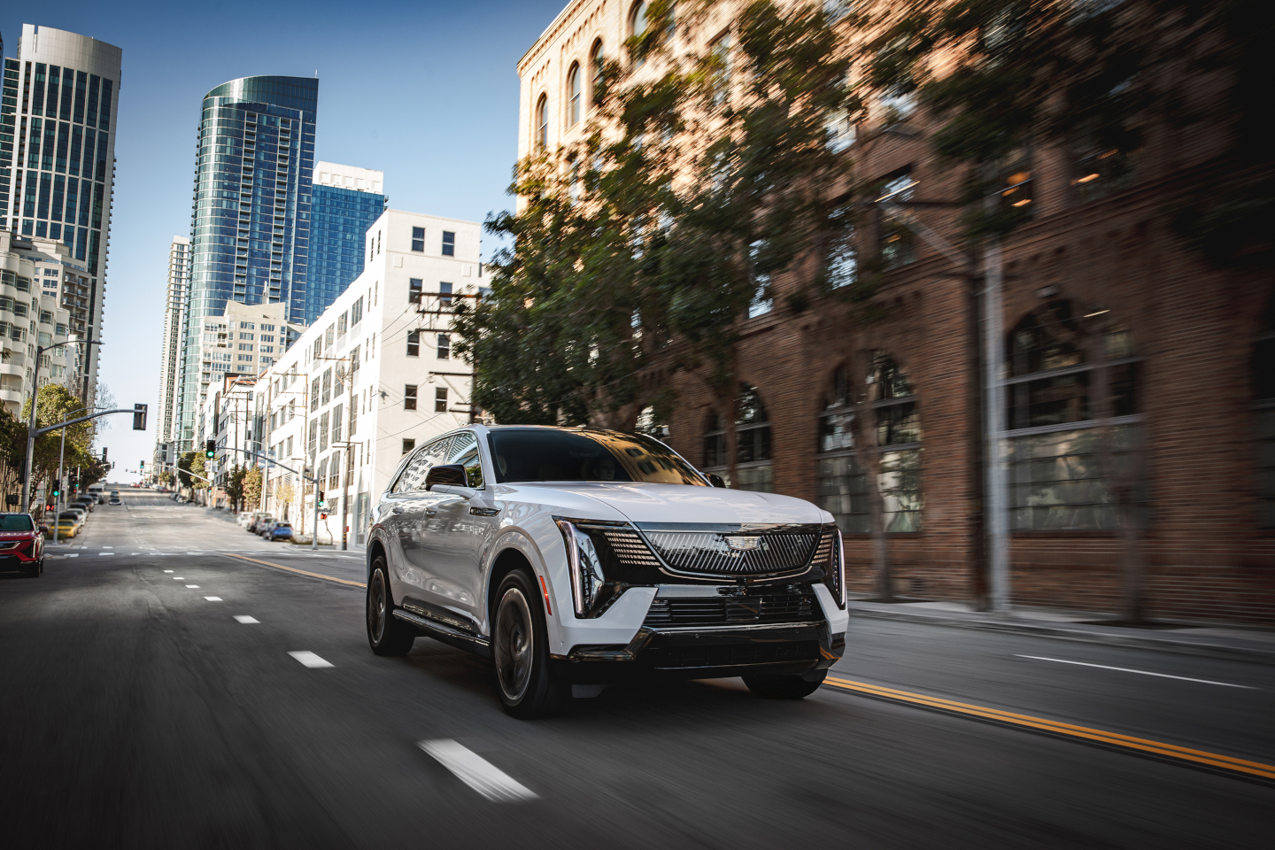 Summit White Cadillac Escalade IQ driving on a city street
