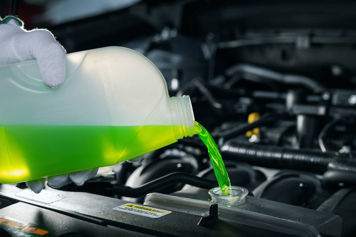 Coolant being poured into a car radiator