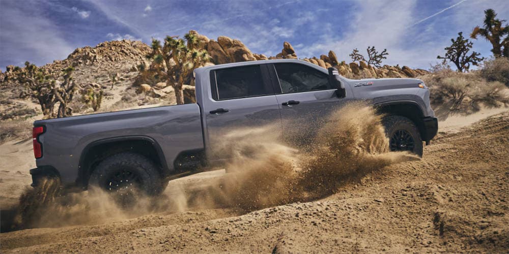 2025 Chevy Silverado 2500 HD driving through dirt
