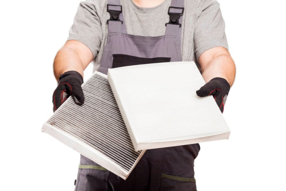mechanic holding an air filter replacement