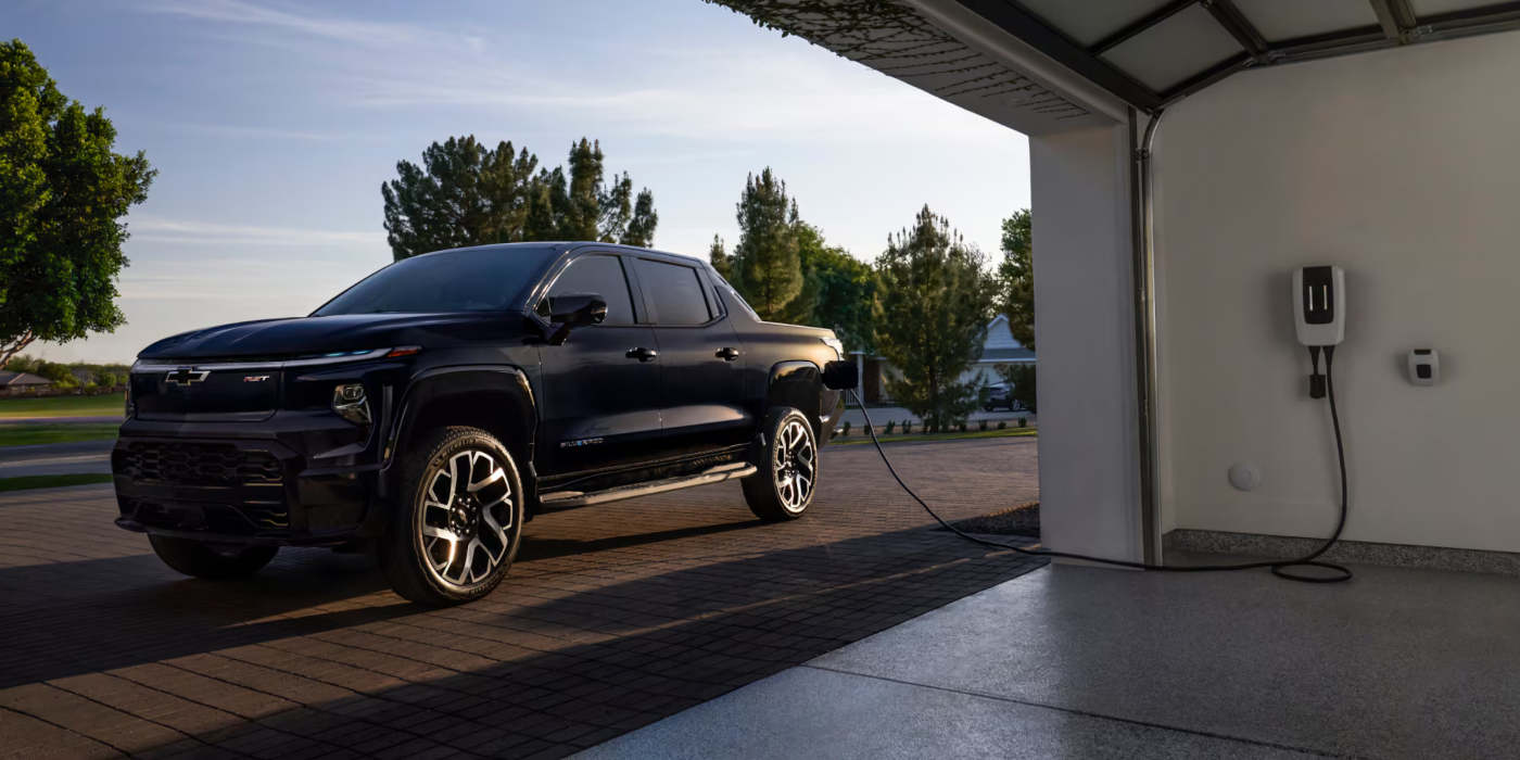 2025 Chevy Silverado EV charging outside a garage