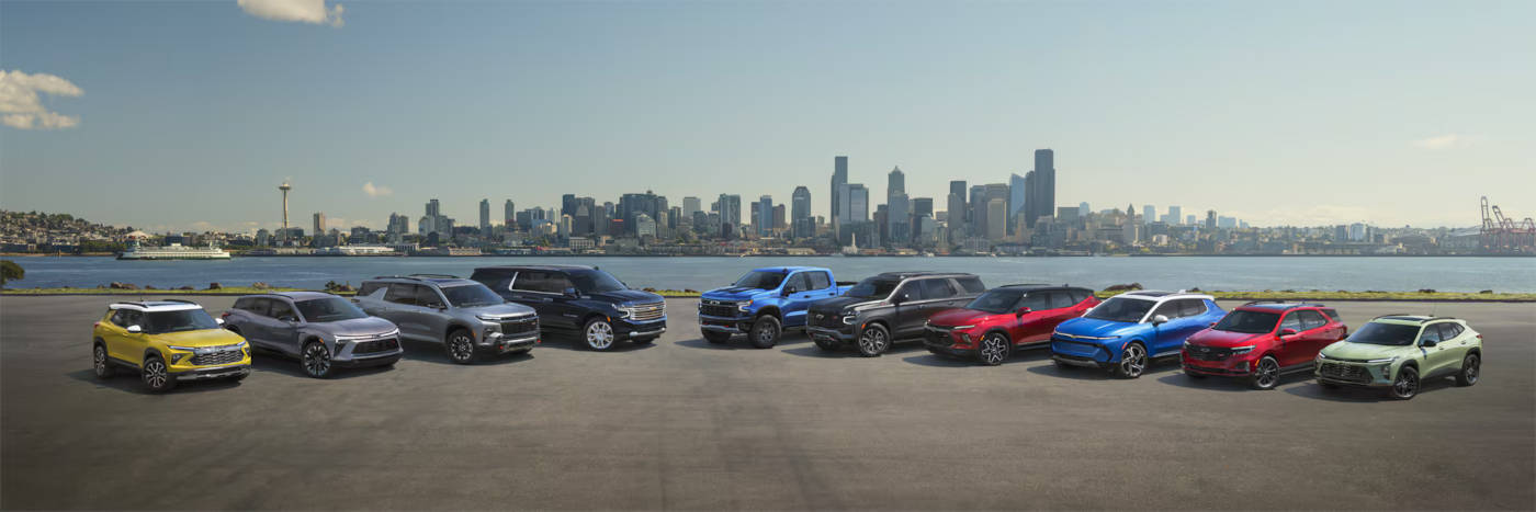 All Chevrolet vehicles parked in front of a river with the city skyline in the background