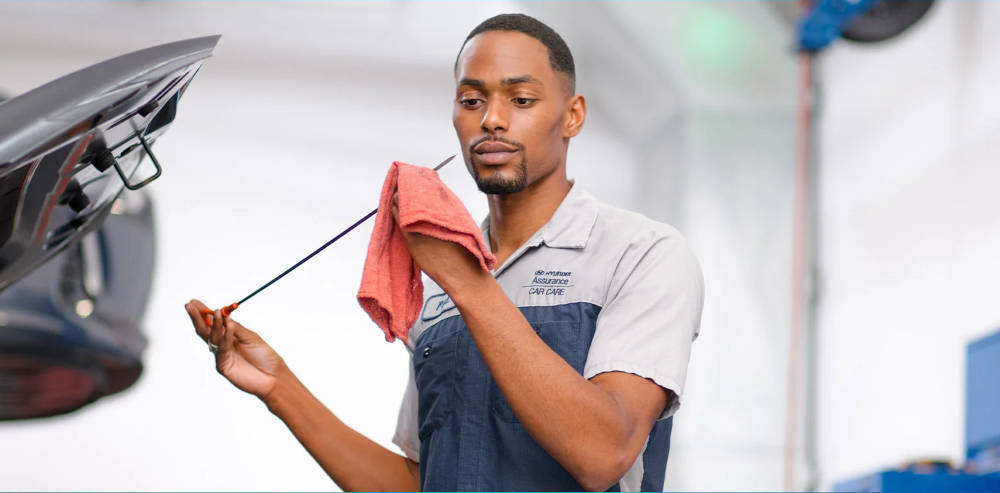 Hyundai mechanic checking oil levels 