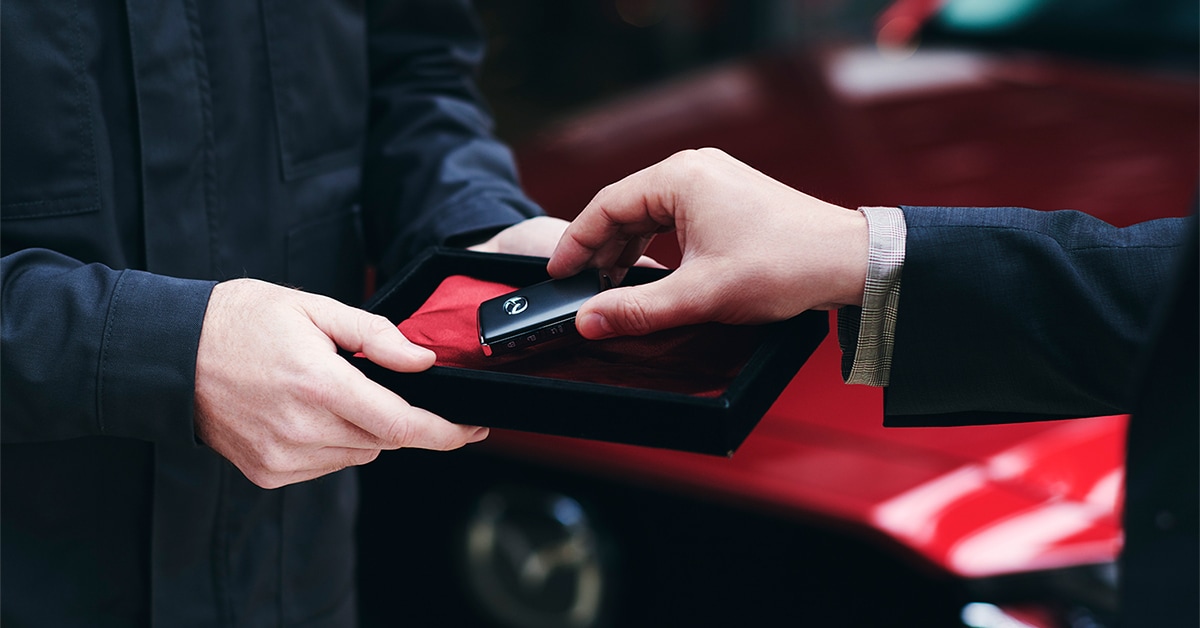 Colonial Mazda sales representative handing a customer keys to new car