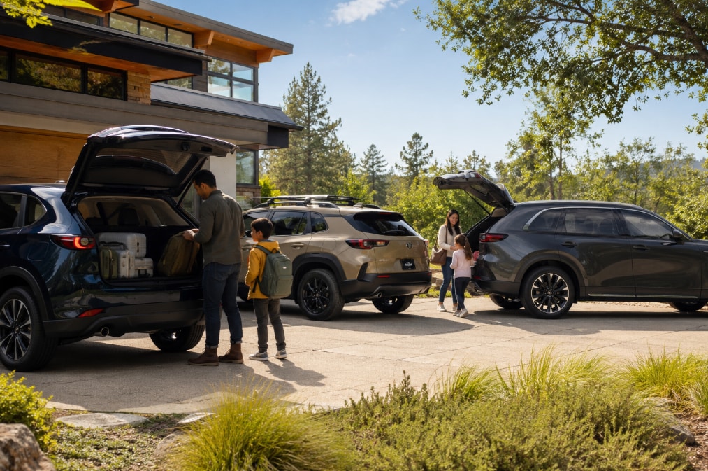 Family loading gear into Mazda SUVs for a weekend adventure.