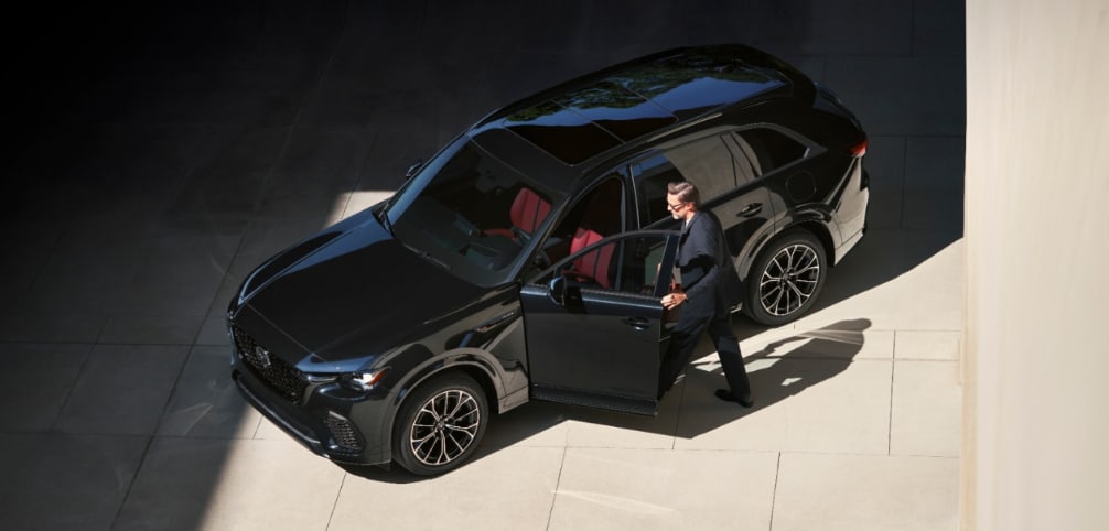 Man getting out of a black 2026 MAZDA CX-70 aavailable in Danbury, CT.