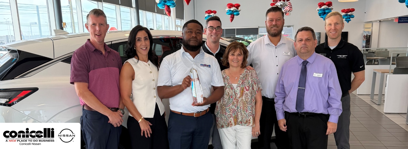 Conicelli Nissan team proudly holding the 2026 Nissan Award of Excellence in the Conshohocken showroom
