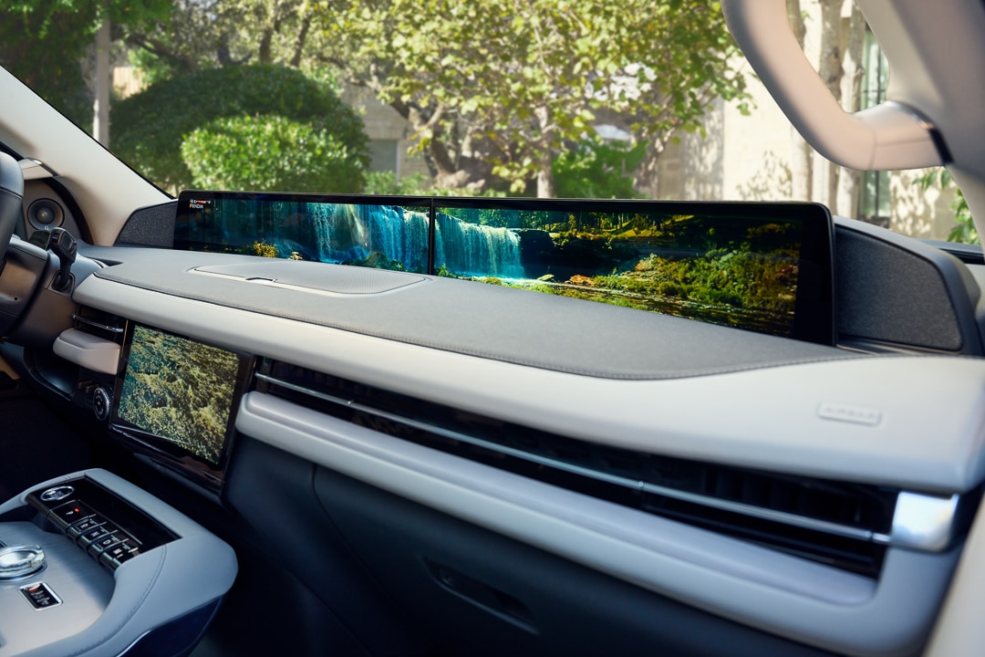 Picture of 2025 Lincoln Navigator Reserve dashboard with bright white interior and 48-inch panoramic screen which displays a waterfall landscape with lush green trees.