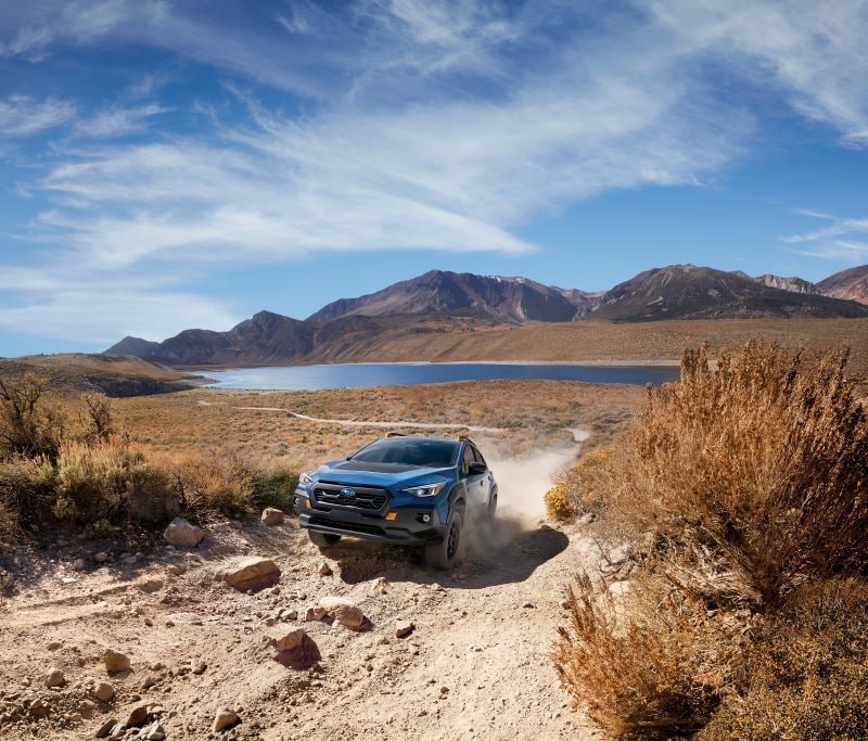 Blue Subaru Crosstrek Wilderness driving on dirt road