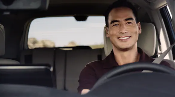front-view-of-man-smiling-while-driving.webp