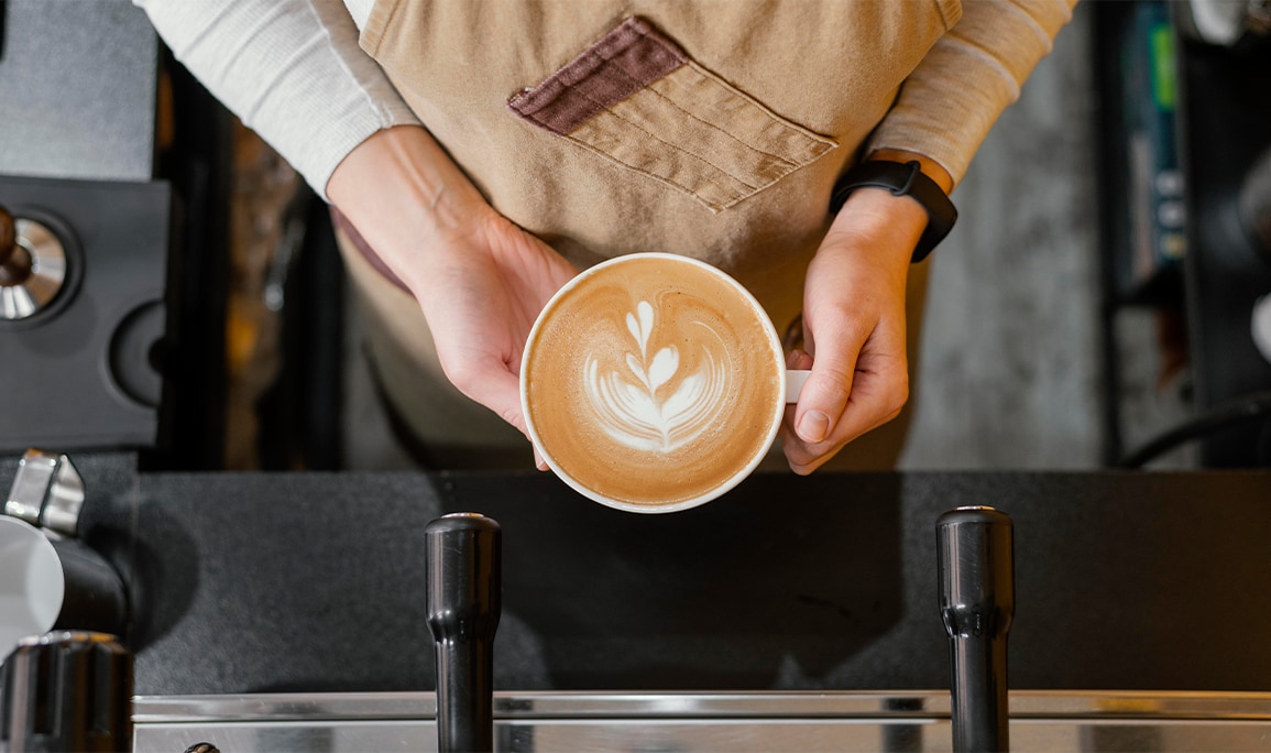 Country Nissan Dealership near Hadley, MA | Barista holding a freshly made coffee