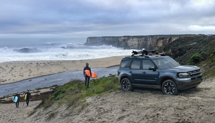 New Ford Bronco at the beach with surfers